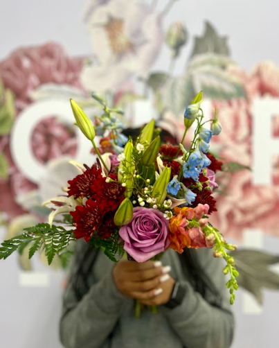 Screenshot-2024-03-29-103001 Girl holding vibrant bouquet of roses, lilies, and snapdragons